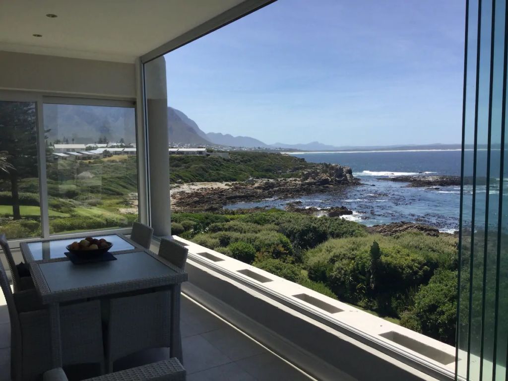 Prime position in Hermanus at the waters edge, with uninterrupted panoramic view of Walker Bay through its floor to ceiling frameless windows